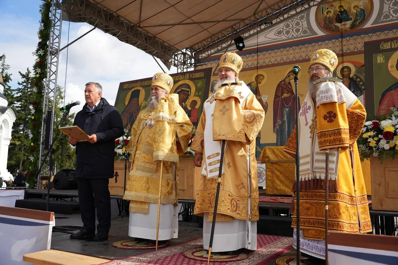 Церковное мероприятие с собранием священнослужителей на сцене.
