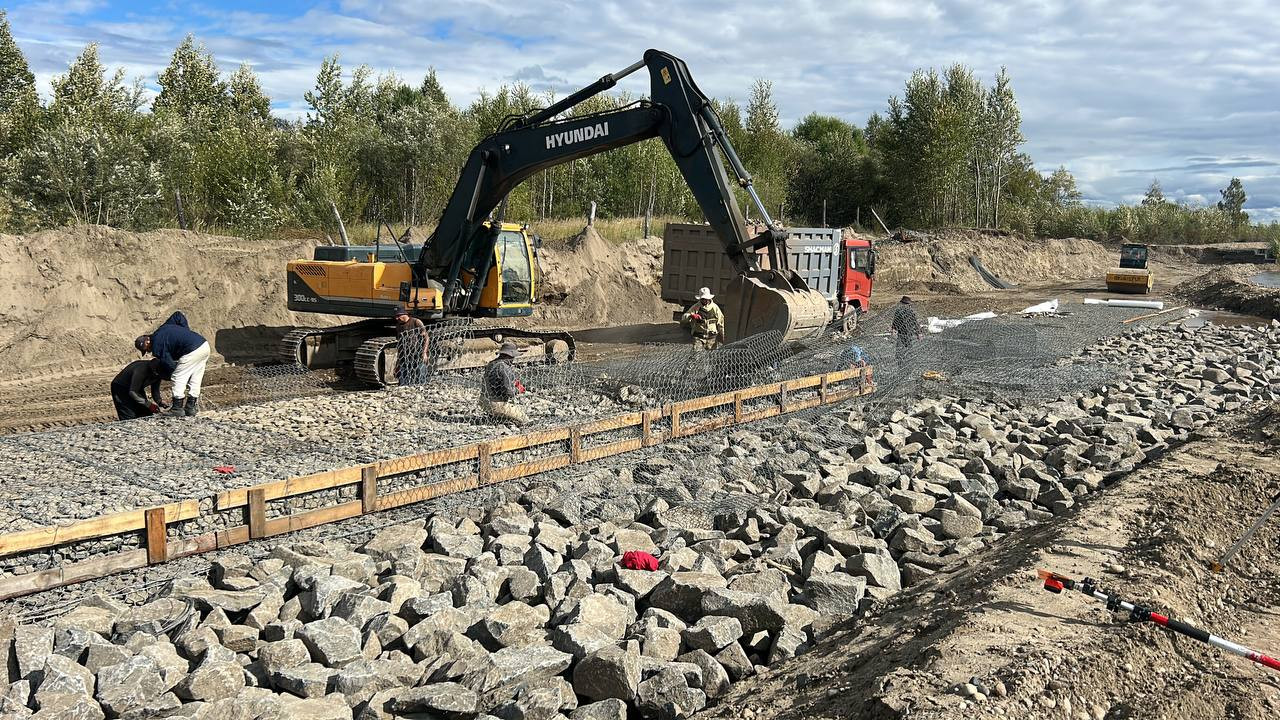 Строительство дороги с экскаватором и рабочими