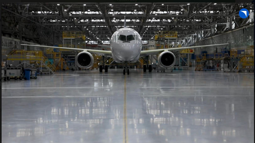 Самолёт в большом ангаре на заводе.