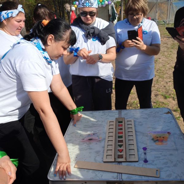 Люди играют настольную игру на улице.