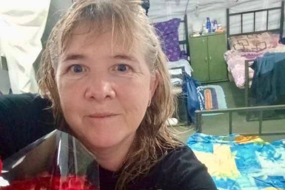 Женщина с цветами в комнате с кроватями