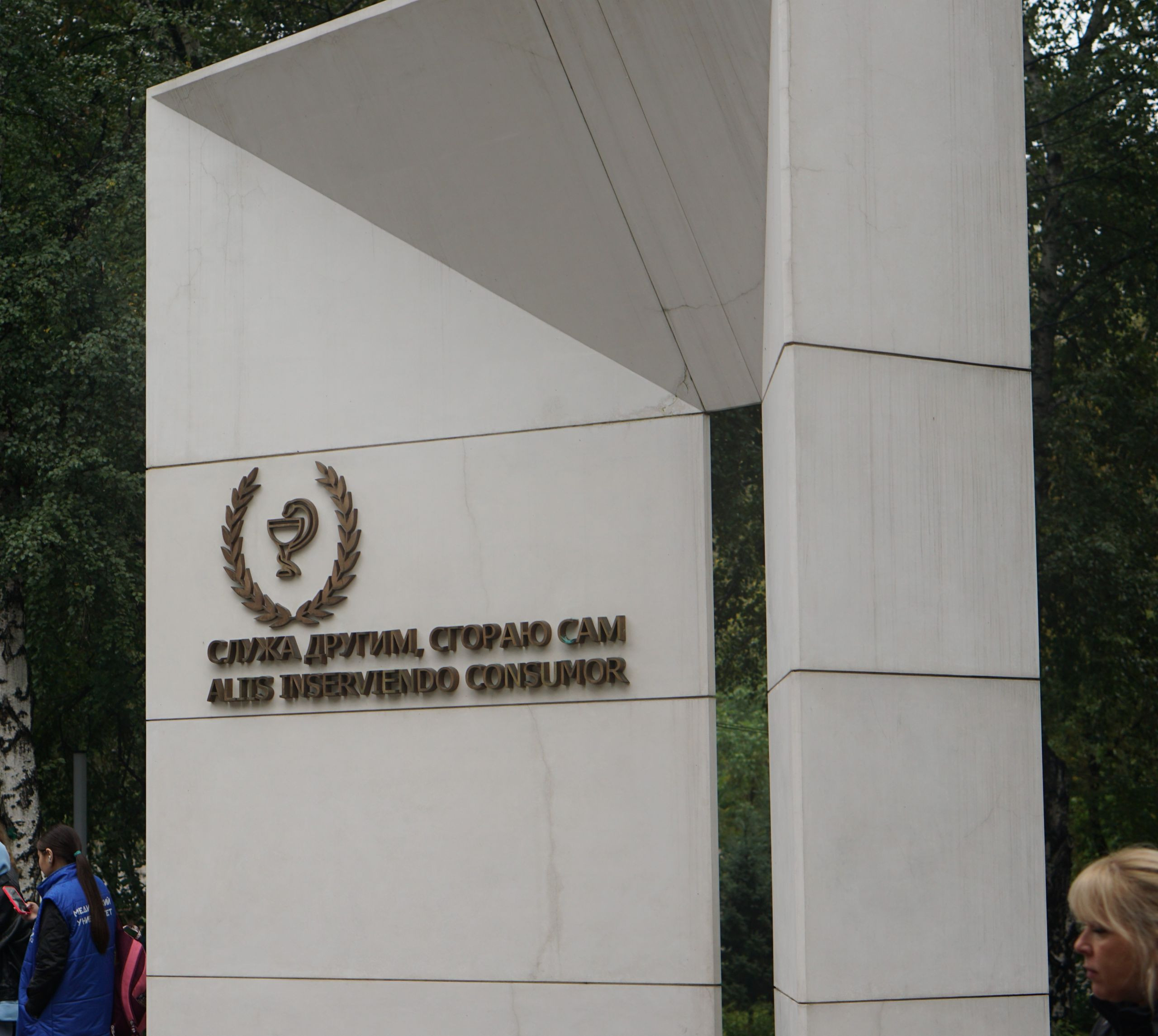 Памятник с латинской фразой в парке