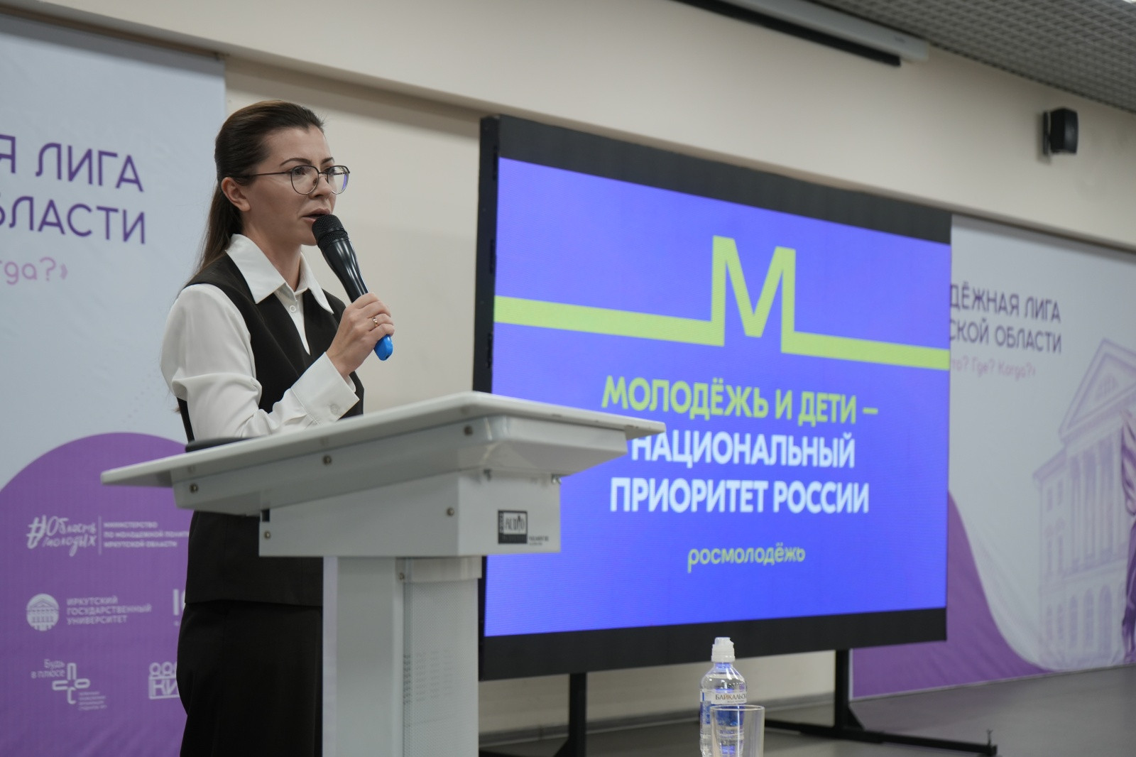 Женщина выступает на конференции о молодёжи и детях.
