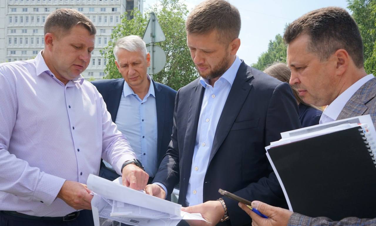 Мужчины обсуждают документы на улице.
