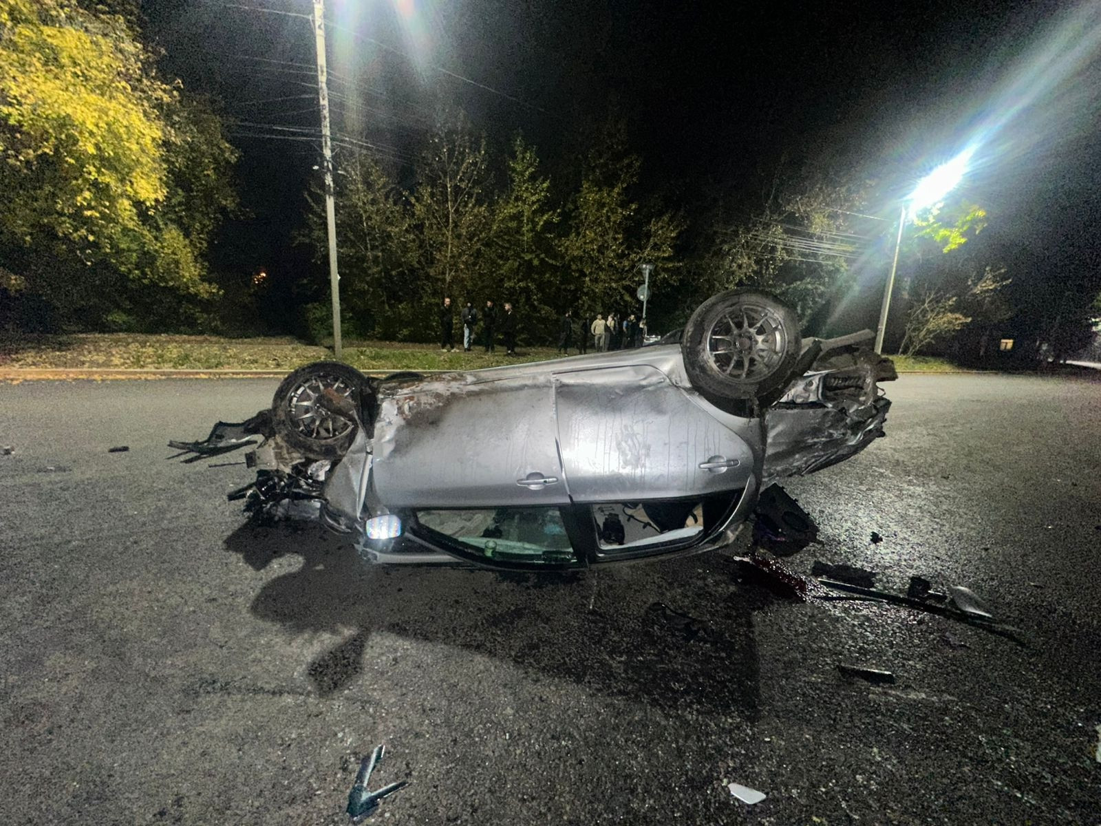 Перевернутая машина после аварии ночью на улице.