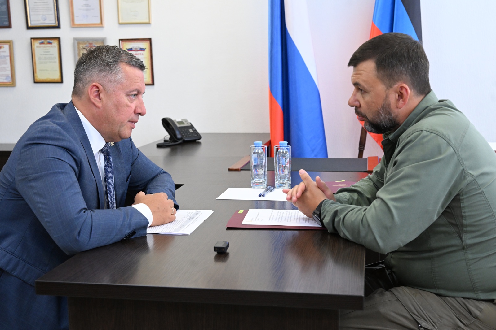 Два мужчины ведут деловую беседу за столом.