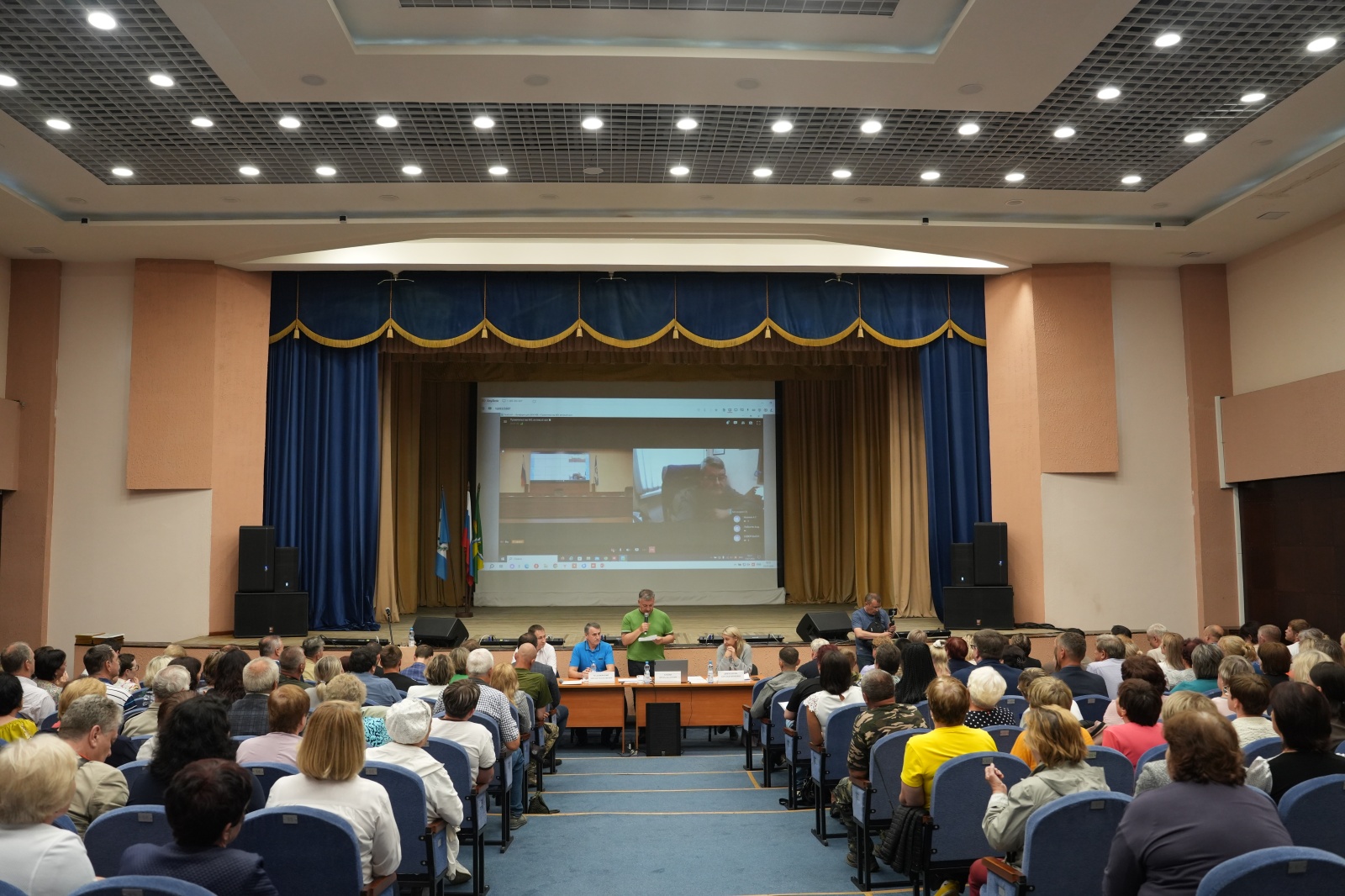 Люди на собрании с презентацией на экране.