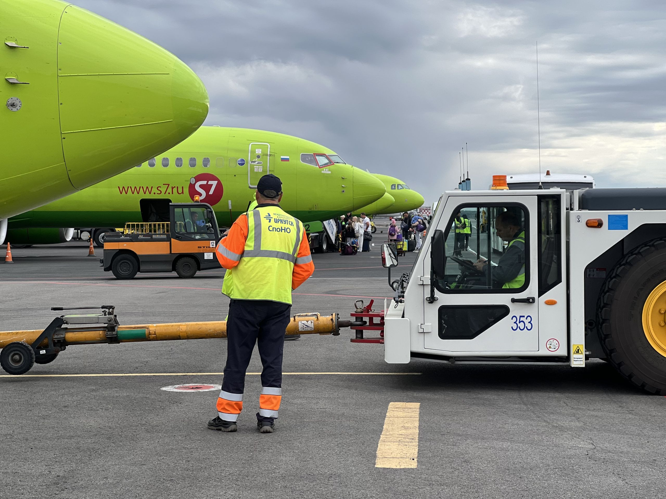 Самолет и техника на взлетно-посадочной полосе.