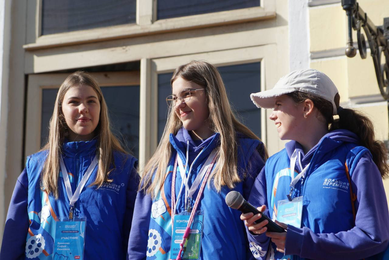 Три девушки на улице в синих куртках.