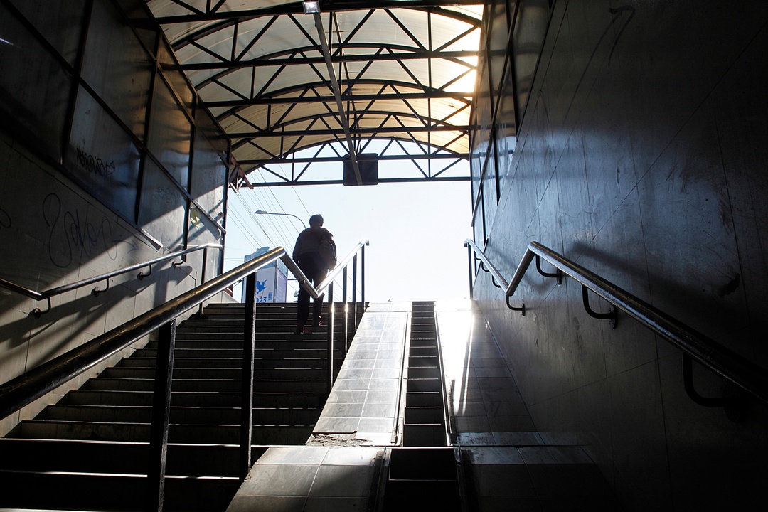 Человек поднимается по лестнице станции метро.