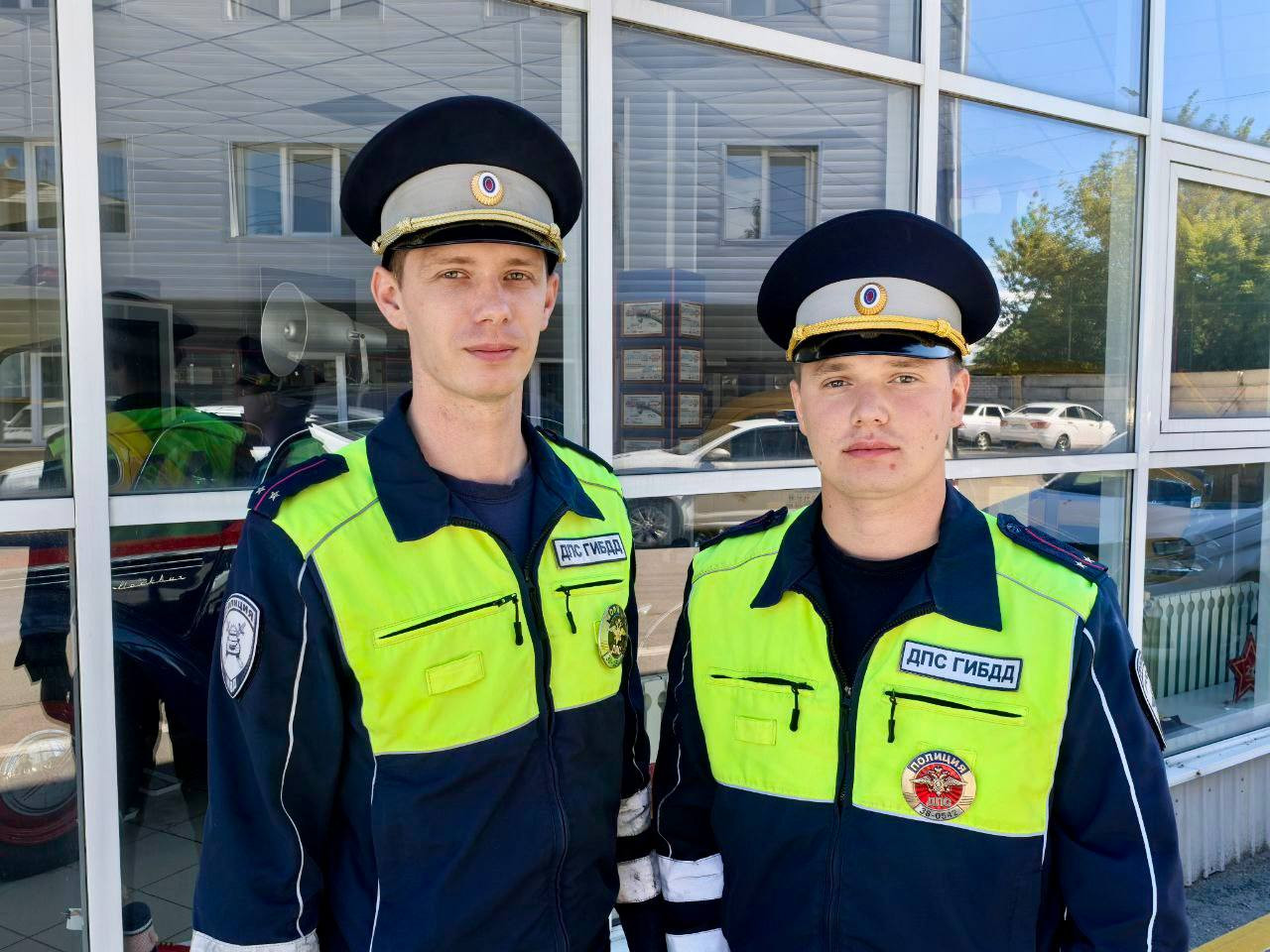 Два сотрудника ДПС в униформе у здания.