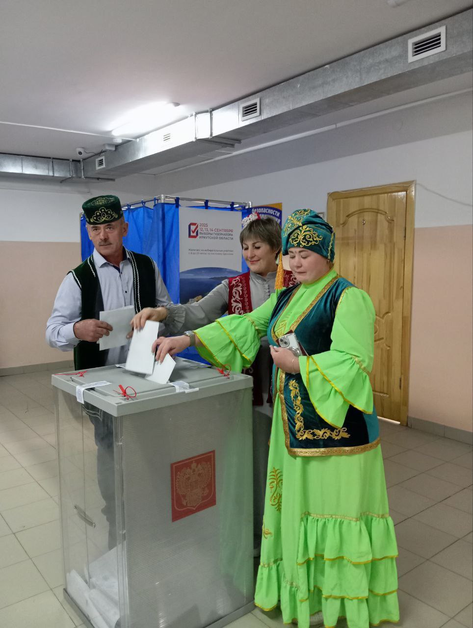 Люди голосуют в национальных костюмах на выборах.