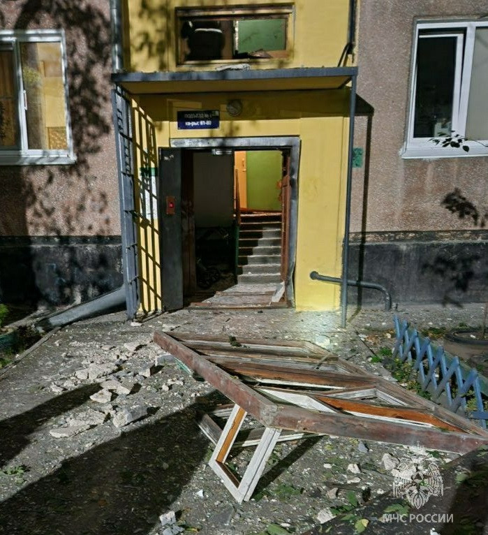 Повреждённая входная дверь здания после аварии.