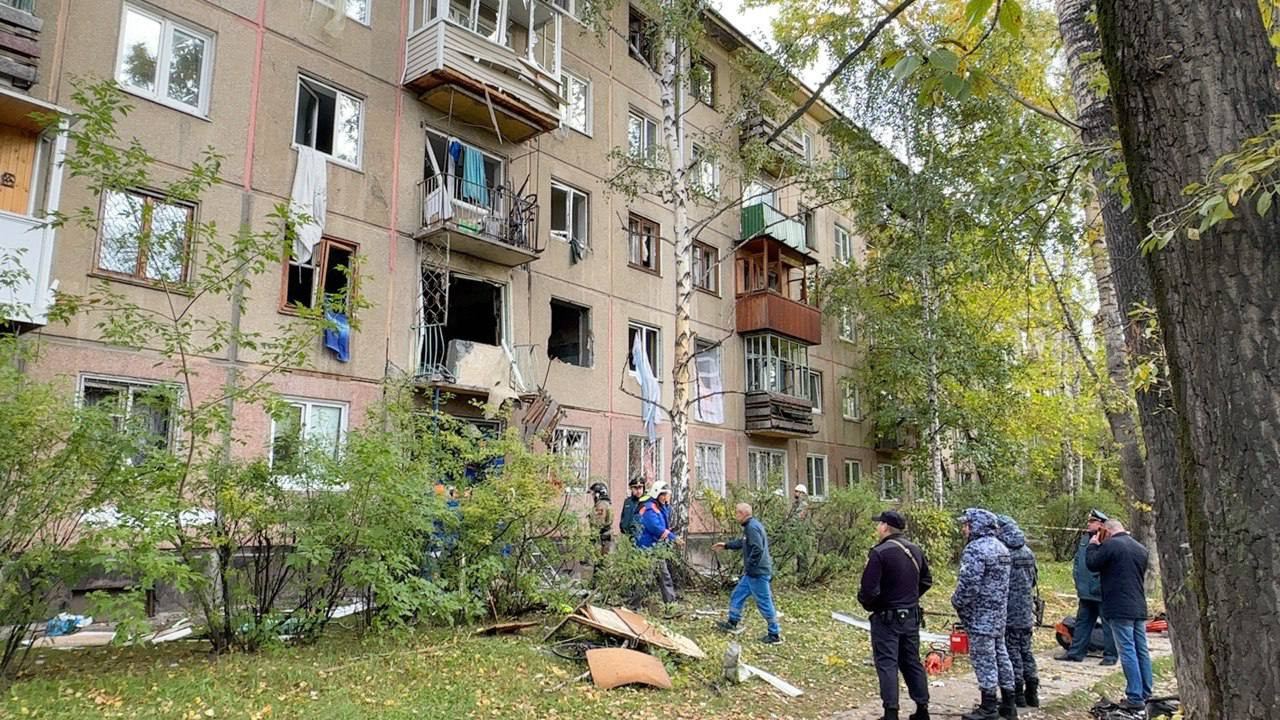 Поврежденный дом после взрыва, спасатели на месте.