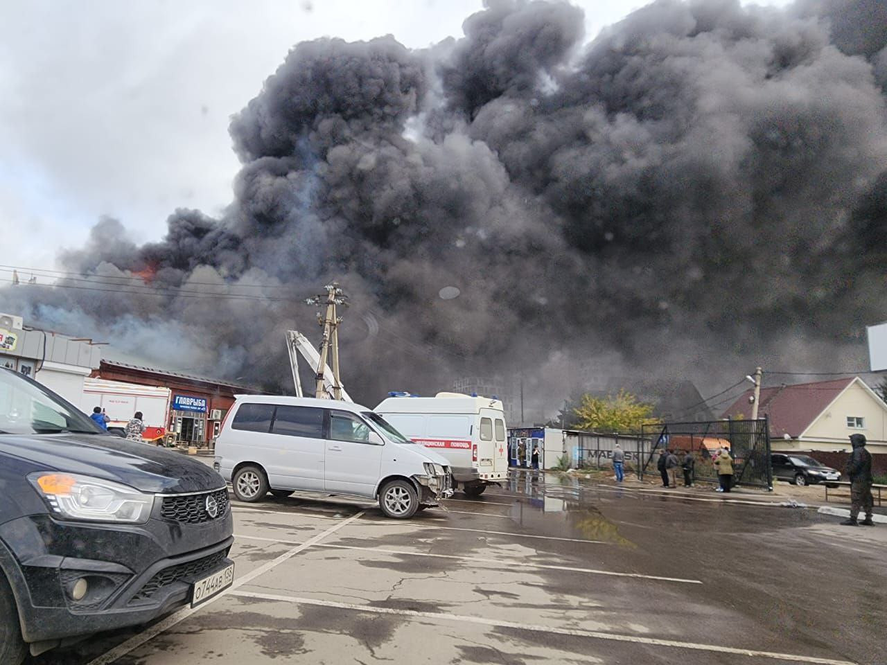 Пожар, черные клубы дыма над зданиями и машинами.