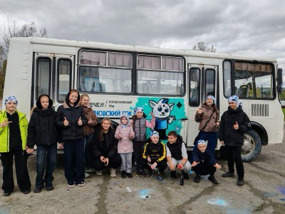 Дети возле автобуса на улице под облачным небом.