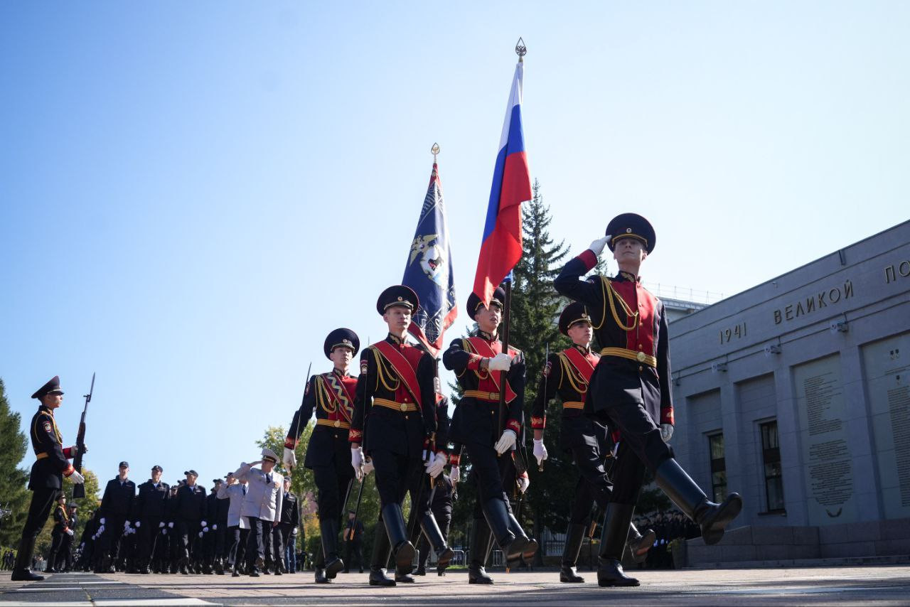 Военный парад с российским флагом на улице.