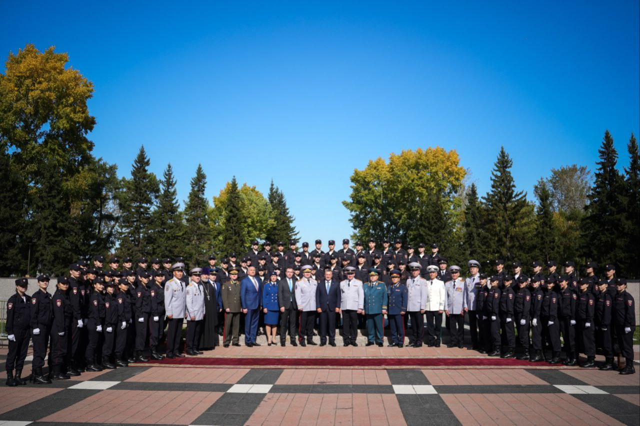 Группа людей в форме позирует на улице.