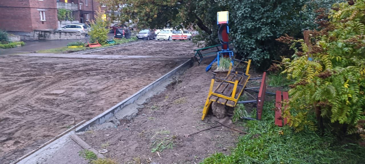 Строительная площадка с грязными дорогами и зеленью.