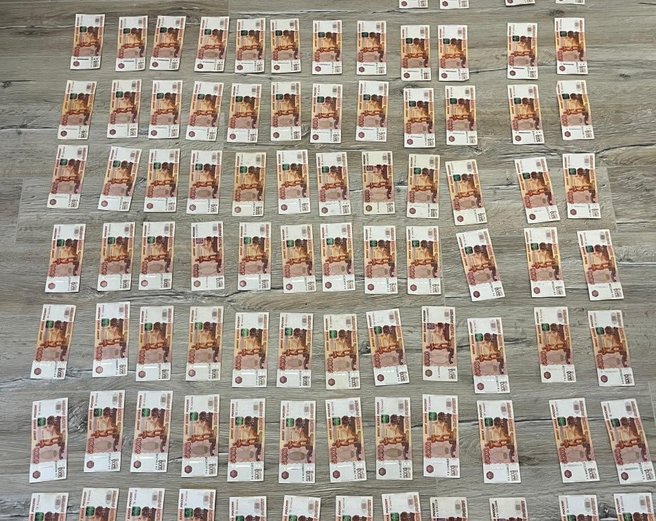 Множество 5000-рублёвых купюр расставлены на полу.