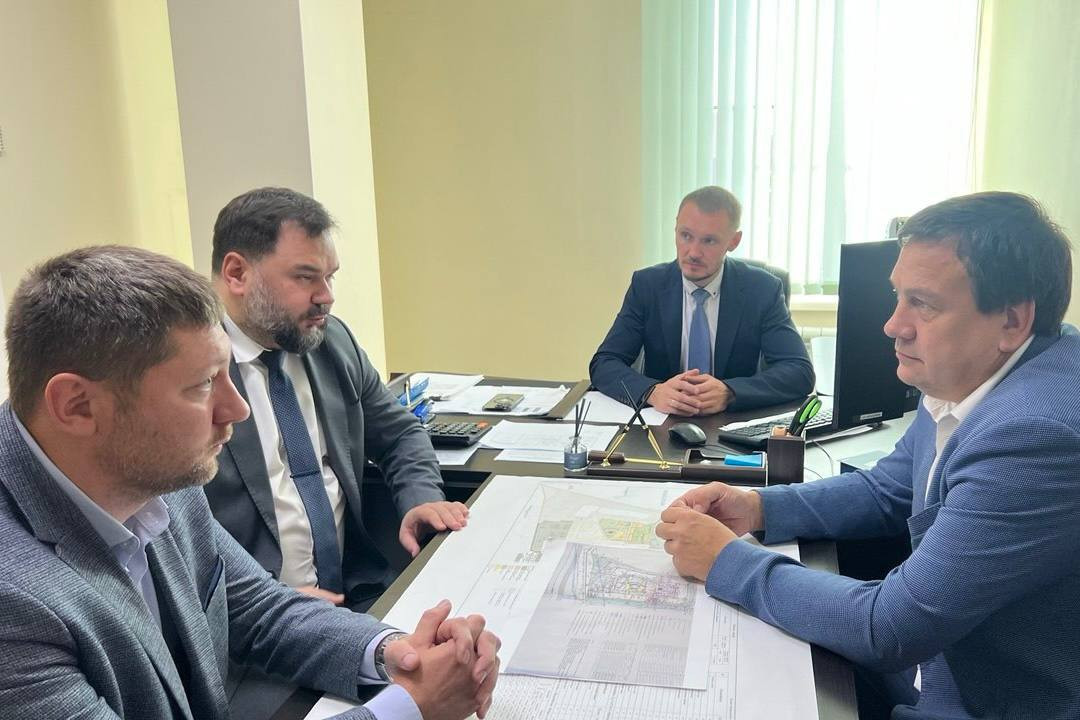 Четыре мужчины обсуждают проект на совещании.