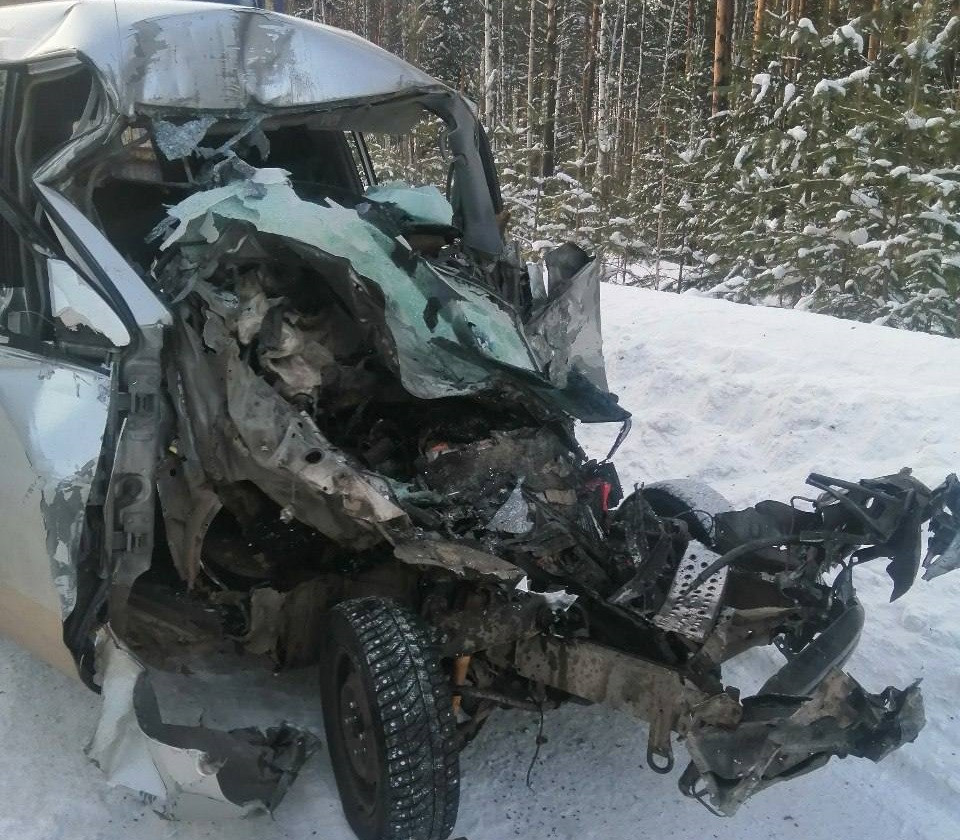 Разбитая машина после аварии на заснеженной дороге.