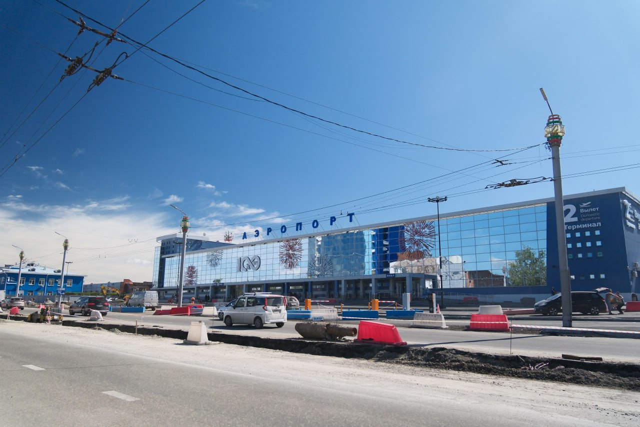 Современный аэропорт с автомобилями перед зданием