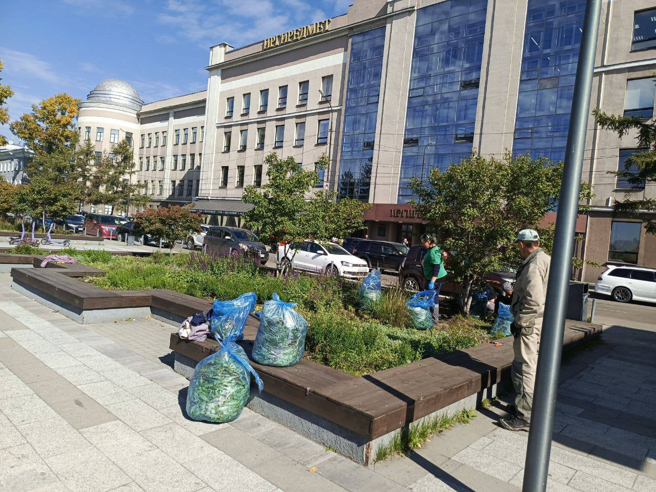Рабочие убирают мусор в городском сквере.