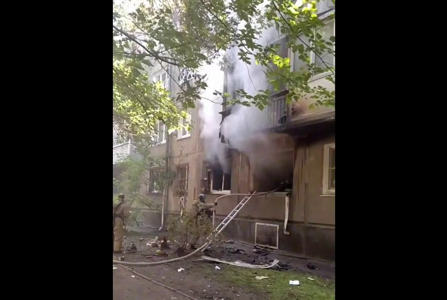 Пожарные тушат дымящийся дом