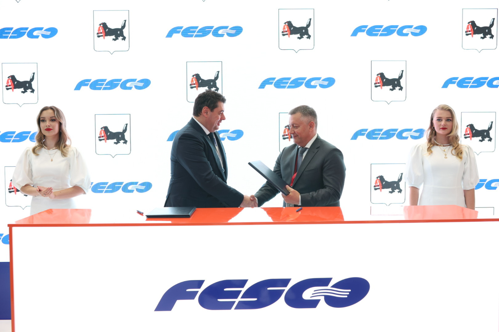Подписание соглашения FESCO партнёрами, логотип на фоне.