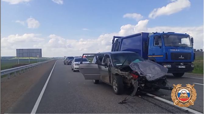 Авария на шоссе: поврежденный автомобиль и грузовики.