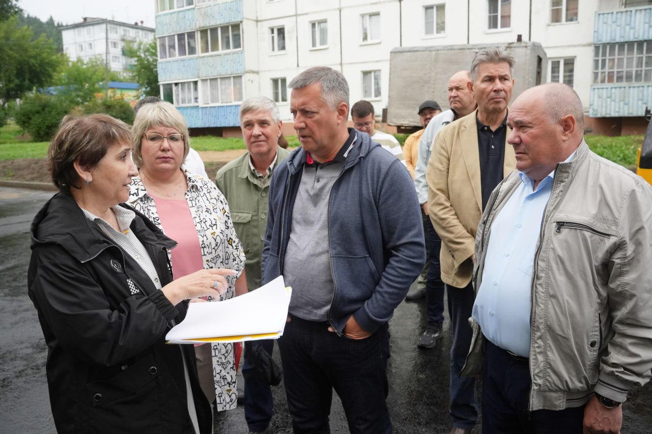 Группа людей обсуждает документацию на улице.