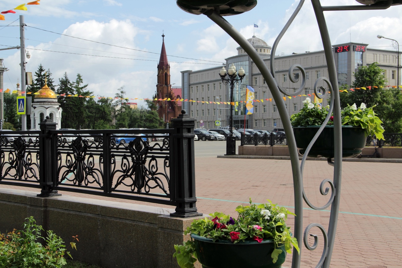Площадь с цветами и историческими зданиями.