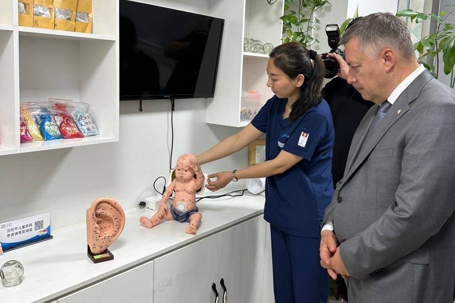 Женщина показывает мужчине медицинскую модель младенца.