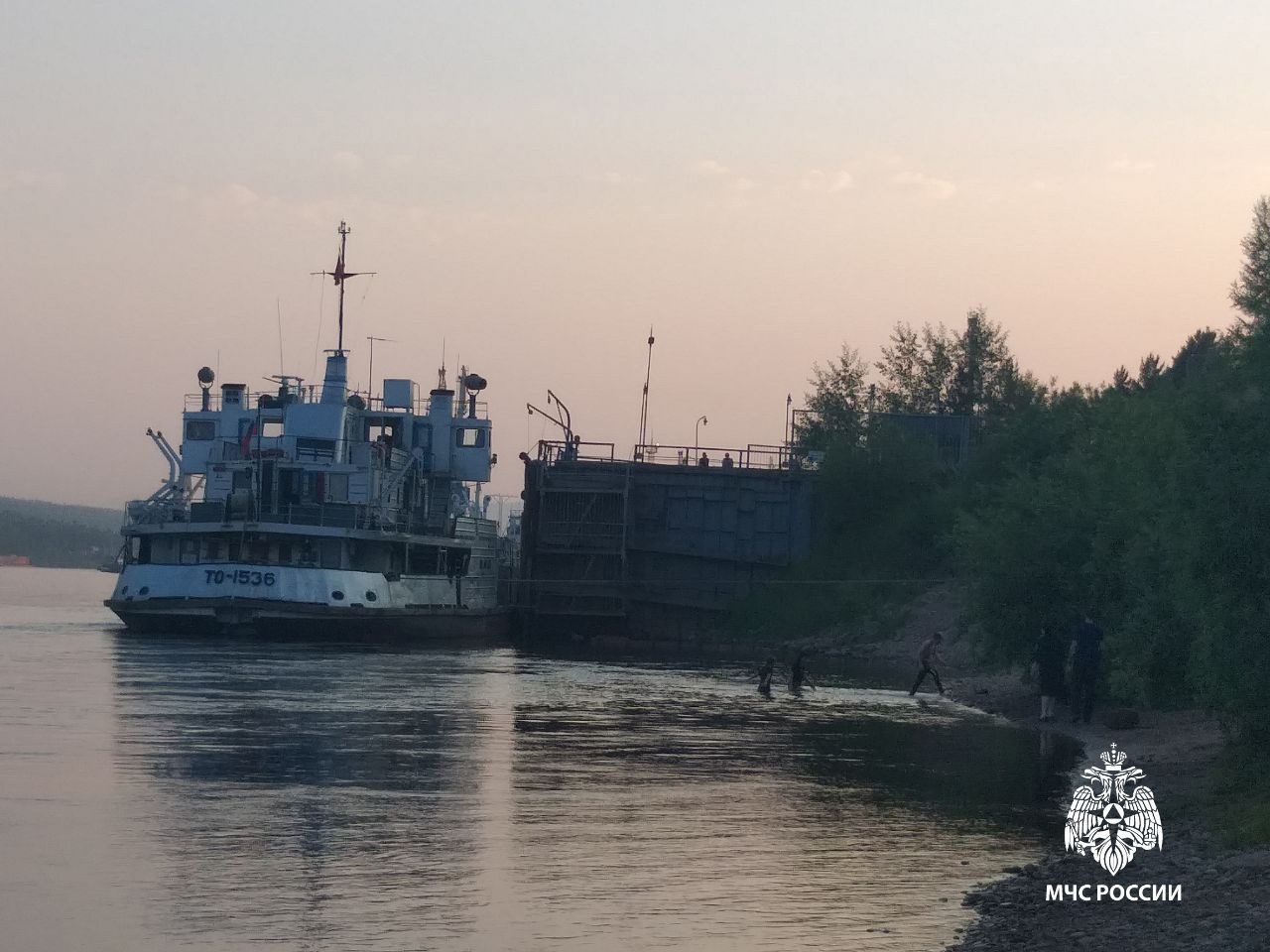 Корабль у причала на реке на закате.