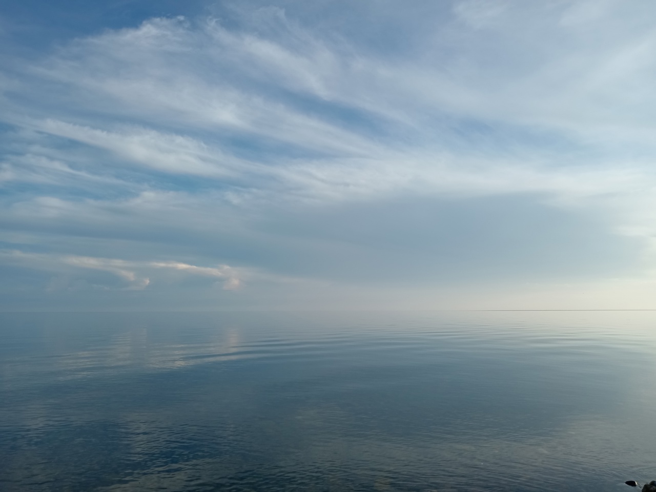 Спокойное море и голубое небо с облаками