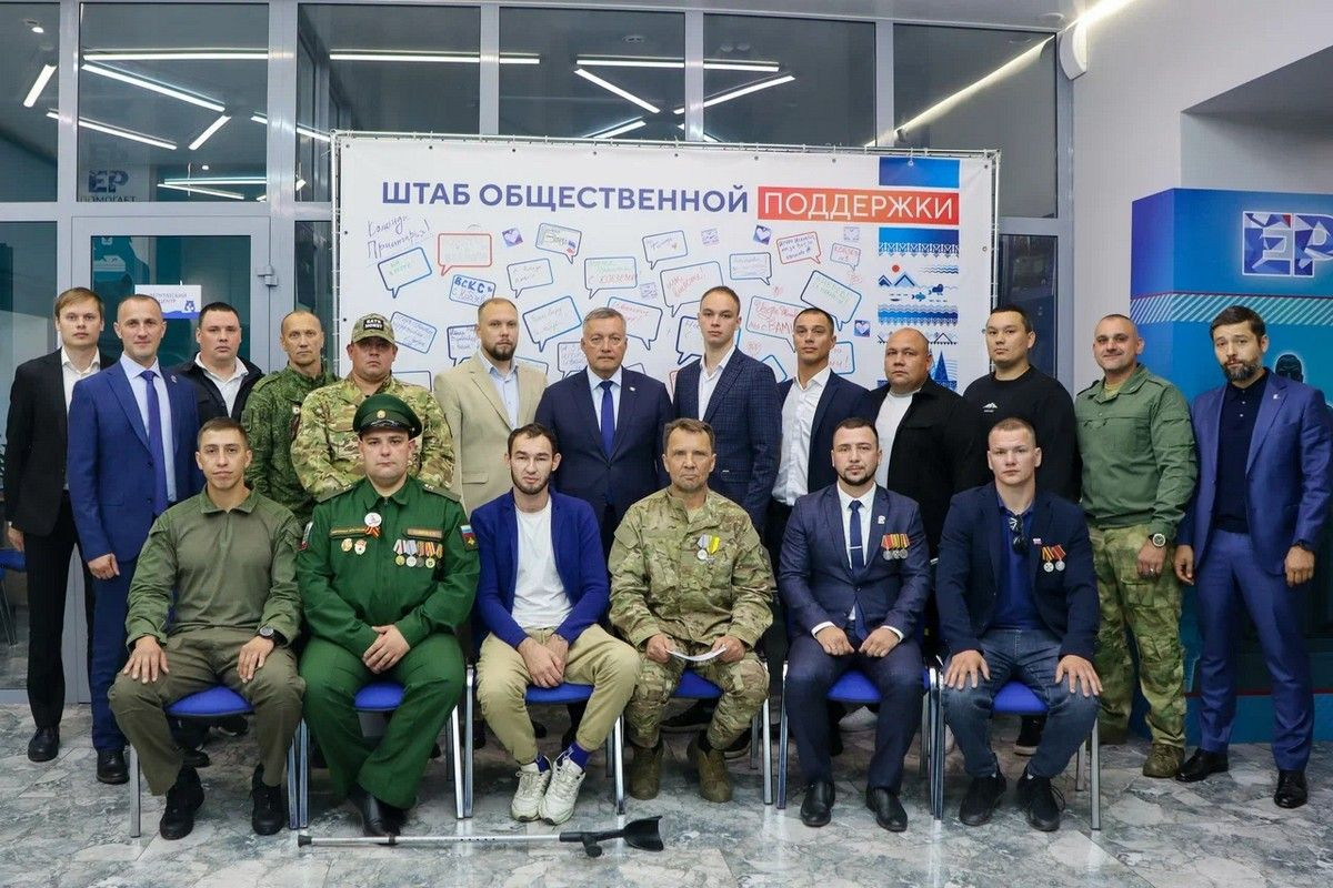 Группа людей на фоне баннера общественной поддержки.