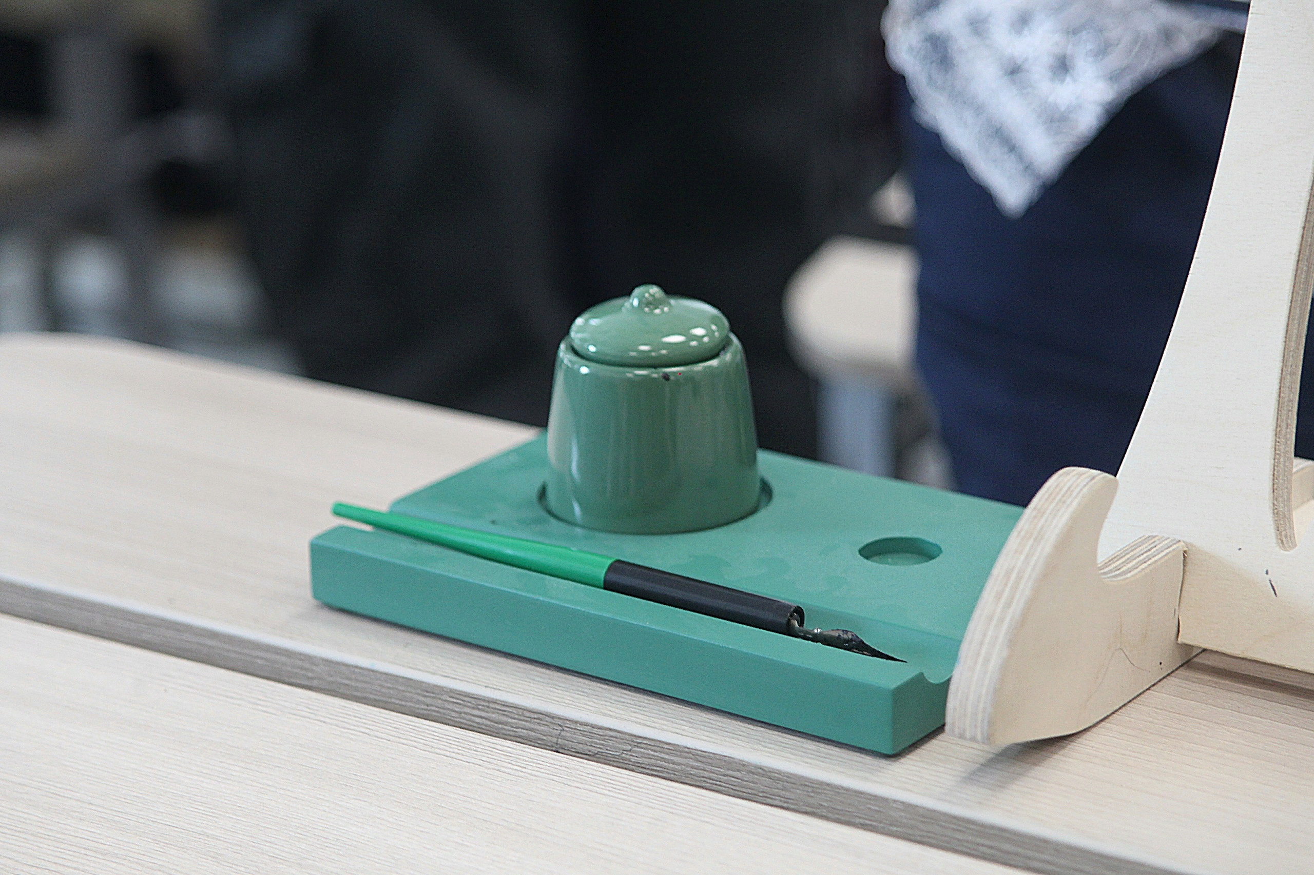 Чёрнильница и перо на столе.